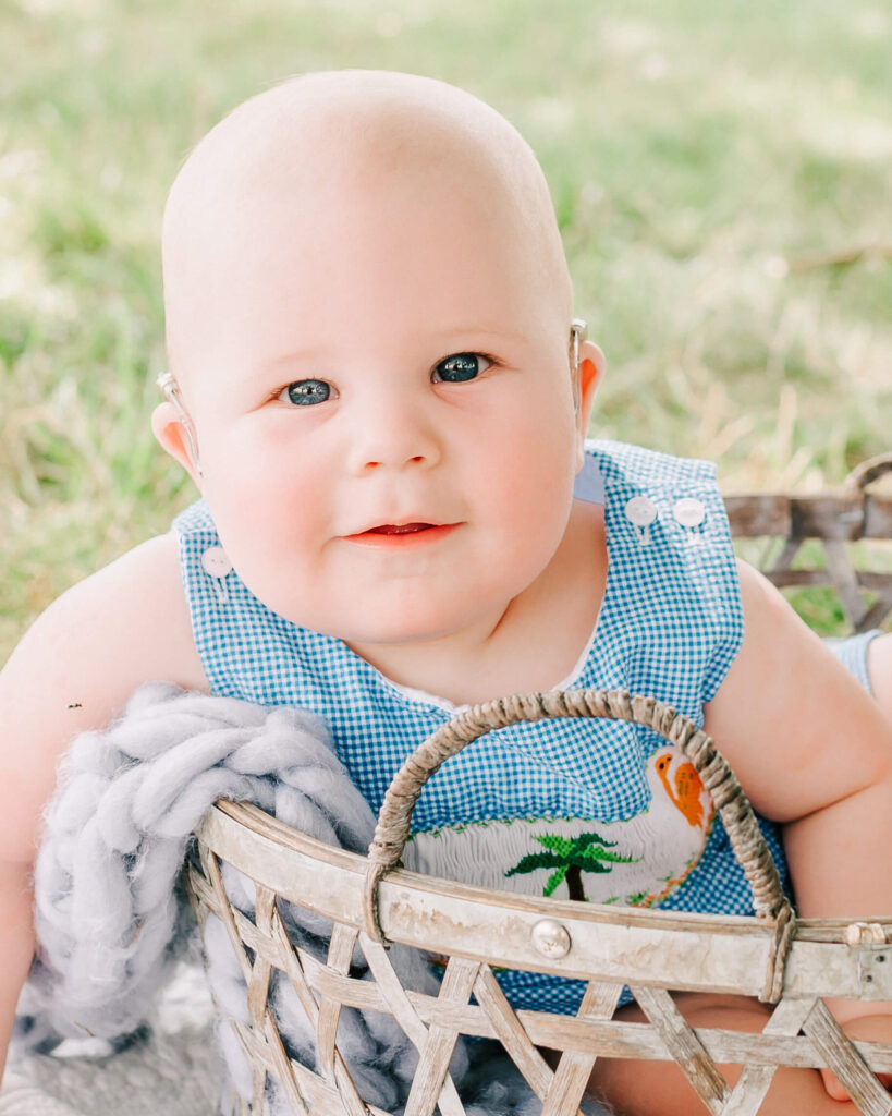 baby dressed in blue sitting in a basket in a field Louisville KY Pediatricians