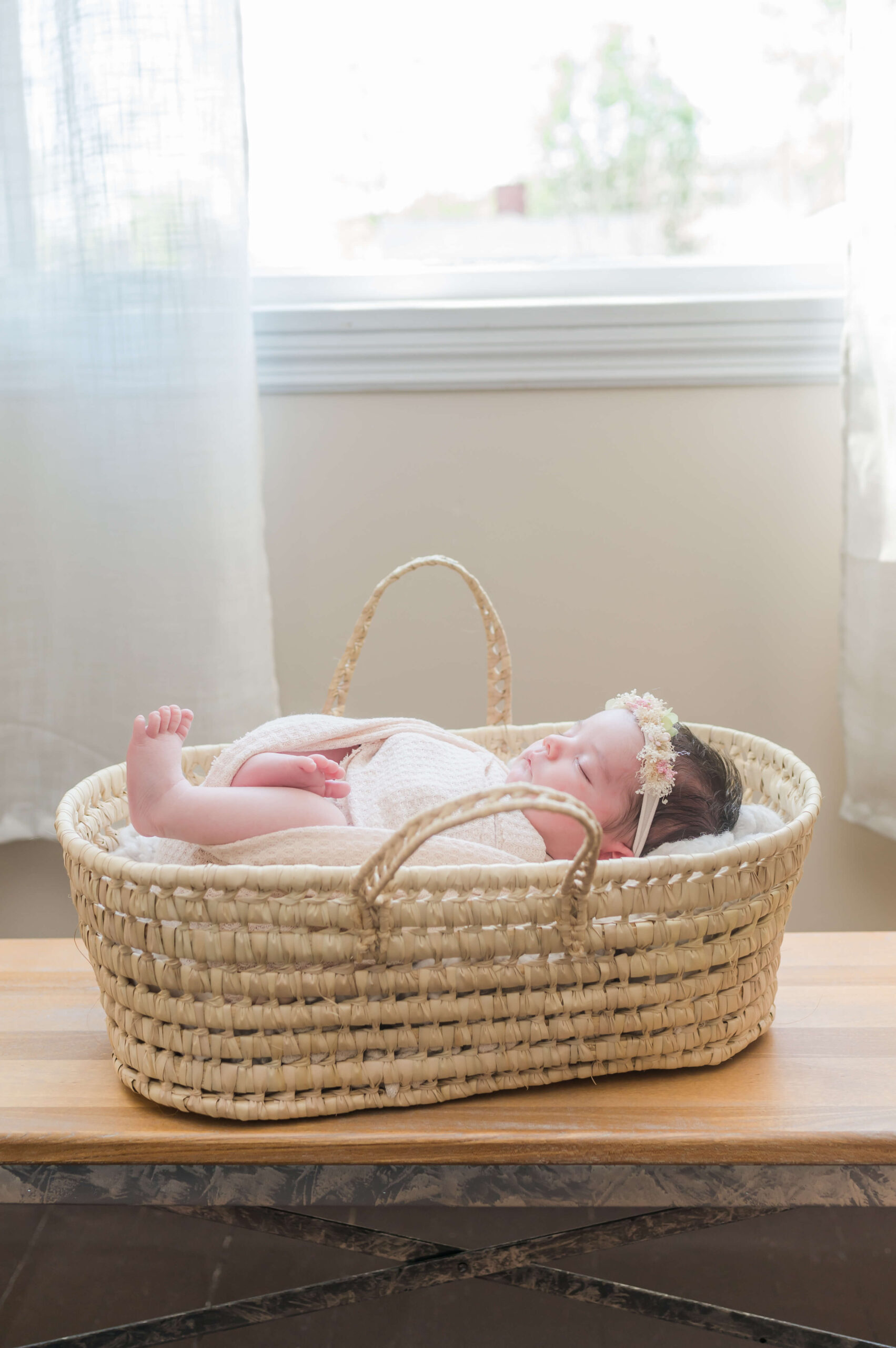 newborn baby sleeping in a moses basket