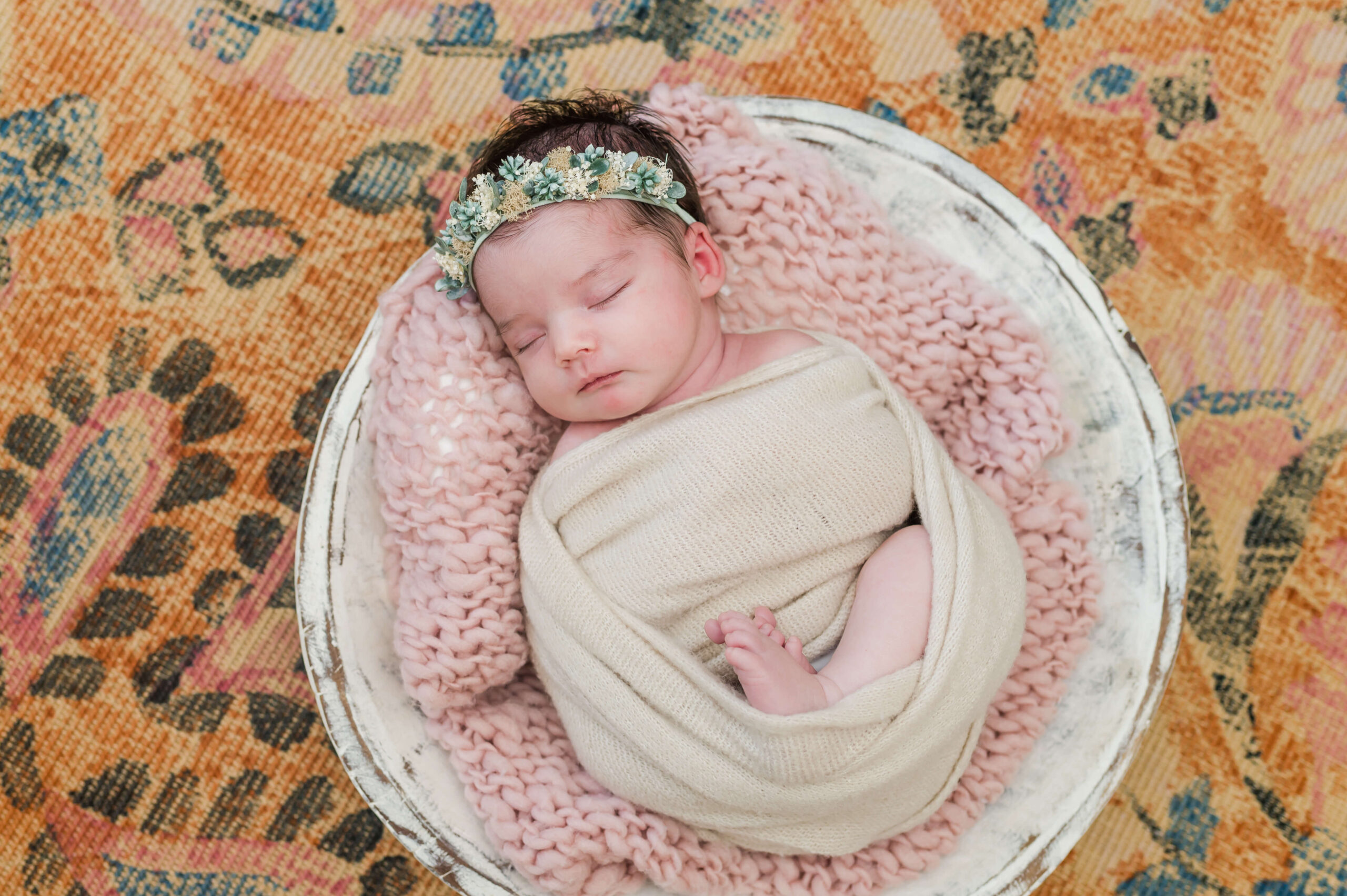 newborn baby girl in a tan wrap sleeping in a basket molly monkey kid furniture
